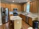 Well-lit kitchen features stainless steel appliances, center island, granite countertops, and wood cabinets at 5211 Nicodemus Dr, Plainfield, IN 46168