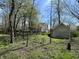 A serene backyard with mature trees, grass, and a quaint shed, perfect for outdoor enjoyment at 1612 S Jeanne Ct, New Palestine, IN 46163