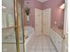 A bathroom featuring a shower with gold trim, a soaking tub, and white tiling at 1612 S Jeanne Ct, New Palestine, IN 46163
