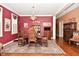 Elegant dining room with red walls, hardwood floors, and a decorative rug at 1612 S Jeanne Ct, New Palestine, IN 46163