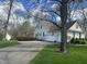Well-maintained home exterior featuring an attached two-car garage, mature trees, and a freshly paved driveway in a suburban neighborhood at 1612 S Jeanne Ct, New Palestine, IN 46163