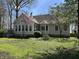 Home exterior with a well-manicured lawn, mature trees, and a view of the rear deck and lush surrounding greenery at 1612 S Jeanne Ct, New Palestine, IN 46163
