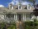 Inviting home exterior featuring a wooden access ramp, three dormer windows, white columns, and a beautiful front yard at 1612 S Jeanne Ct, New Palestine, IN 46163