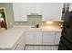 Kitchen features white cabinetry, laminate countertops, stainless steel faucet, and a sink at 1612 S Jeanne Ct, New Palestine, IN 46163
