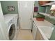 Convenient laundry room features a washing machine, dryer, shelving, and utility sink at 1612 S Jeanne Ct, New Palestine, IN 46163