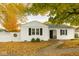 Charming single-story home with white siding, black shutters, and a well-maintained front yard filled with fall leaves at 610 E Morgan St, Martinsville, IN 46151