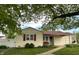 Quaint single-Gathering home with yellow siding, red shutters, and a well-manicured lawn with mature trees for shade at 610 E Morgan St, Martinsville, IN 46151