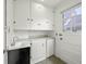 Bright laundry room featuring white cabinets, a sink, and a door to the outside at 610 E Morgan St, Martinsville, IN 46151
