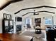 Bright living room featuring hardwood floors, fireplace, and vaulted ceilings with dark wood beams at 610 E Morgan St, Martinsville, IN 46151