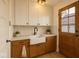 Stylish mudroom with cabinets, a farmhouse sink, and a wooden door; perfect for organization and functionality at 610 E Morgan St, Martinsville, IN 46151