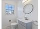 Updated bathroom with gray vanity and circular mirror at 2103 Danbury Dr, Indianapolis, IN 46231