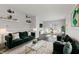 Spacious living room with dark hardwood floors and green velvet sofas at 2103 Danbury Dr, Indianapolis, IN 46231