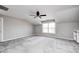 Spacious carpeted bedroom featuring a ceiling fan, neutral paint, and a large window at 6502 Allisonville Rd, Indianapolis, IN 46220