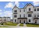 Charming new construction townhome with crisp white siding, black trim, covered entry, and well-manicured lawn at 4231 Barrel Ln, Westfield, IN 46062