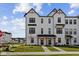 Charming new construction townhome with crisp white siding, black trim, covered entry, and well-manicured lawn at 4231 Barrel Ln, Westfield, IN 46062