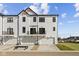 Modern townhome featuring three garages, second story balconies, and sleek white siding for stylish curb appeal at 4231 Barrel Ln, Westfield, IN 46062