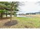 A grassy area with a lake view, a row of townhomes, and bare trees at 7854 Harbour Isle, Indianapolis, IN 46240