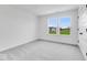 Well-lit bedroom with grey carpet, two windows, and a door at 9275 Loyola Way, Plainfield, IN 46168