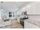White kitchen with granite countertops and stainless steel appliances at 9275 Loyola Way, Plainfield, IN 46168