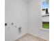Laundry room with tile floor and window for natural light at 9275 Loyola Way, Plainfield, IN 46168