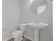 The bathroom features a pedestal sink, modern fixtures, and a round mirror at 10133 Redwood Peak Ln, Indianapolis, IN 46259
