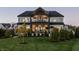 Beautifully landscaped backyard with a spacious lawn and an inviting covered patio at 10937 Pete Dye Rdg, Zionsville, IN 46077