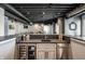 Basement bar featuring under-counter refrigerator and wine storage, stone countertop and custom cabinets at 10937 Pete Dye Rdg, Zionsville, IN 46077