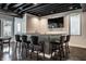 Basement bar area featuring an illuminated bar with seating for six, a sink, and a refrigerator at 10937 Pete Dye Rdg, Zionsville, IN 46077