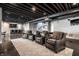 Finished basement with exposed rafters offering a home theater setup and comfortable seating at 10937 Pete Dye Rdg, Zionsville, IN 46077