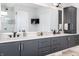 Modern bathroom with dual sinks, sleek gray cabinets, and a glass-enclosed shower at 10937 Pete Dye Rdg, Zionsville, IN 46077