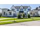 Elegant two-story home with a stone and white brick exterior and a meticulously maintained front lawn at 10937 Pete Dye Rdg, Zionsville, IN 46077
