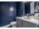 Stylish powder room featuring a blue wall, vanity, and modern sink at 10937 Pete Dye Rdg, Zionsville, IN 46077