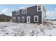 A view of the rear of the house exhibiting its dark gray siding, white trim, and patio exit at 7856 Magnolia St, New Palestine, IN 46163