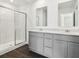 Modern bathroom featuring a double sink vanity, white quartz counters, and a glass enclosed shower at 7856 Magnolia St, New Palestine, IN 46163