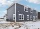 View of the back of the home featuring gray siding, white trim, and an efficient air conditioning unit at 7856 Magnolia St, New Palestine, IN 46163