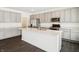 A modern kitchen features an island with a white countertop, gray cabinets and stainless steel appliances at 7856 Magnolia St, New Palestine, IN 46163