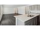 A kitchen island features a stainless steel sink and faucet, with an open-concept living area in the background at 7856 Magnolia St, New Palestine, IN 46163