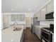 A gourmet kitchen features gray cabinets, stainless steel appliances, a large island and hardwood floors at 7856 Magnolia St, New Palestine, IN 46163