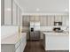 A modern kitchen features gray cabinets, stainless steel appliances, a large island and hardwood floors at 7856 Magnolia St, New Palestine, IN 46163