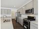 A gourmet kitchen features gray cabinets, stainless steel appliances, and a large island at 7856 Magnolia St, New Palestine, IN 46163