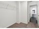 Walk-in closet featuring carpet floors, white walls, and wire shelving, viewed from adjacent bathroom at 7856 Magnolia St, New Palestine, IN 46163