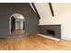 Arched doorway and step-up revealing stairs, fireplace, and hardwood floors at 6470 Around The Hills Rd, Indianapolis, IN 46226