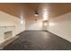 Unfinished basement featuring a decorative fireplace, neutral walls, and overhead lighting at 6470 Around The Hills Rd, Indianapolis, IN 46226