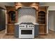 Close up of a stove in the kitchen featuring custom wood cabinets and a decorative backsplash at 6470 Around The Hills Rd, Indianapolis, IN 46226