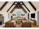 Vaulted ceiling great room featuring dark wood beams, stone fireplace, hardwood floors and bright natural light at 6470 Around The Hills Rd, Indianapolis, IN 46226