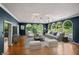 Inviting living room with hardwood floors, multiple windows, modern lighting, a plush sofa and stylish decor at 6470 Around The Hills Rd, Indianapolis, IN 46226
