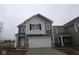 Two story home with an attached garage, covered entry way, and white trim at 5057 Modernist Blvd, Indianapolis, IN 46237