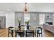Modern dining room with glass top table, black chairs, and view into living room at 628 N Beville Ave, Indianapolis, IN 46201
