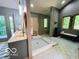 Bathroom featuring spa-like shower, bench, and double vanity next to an outdoor deck at 6438 Pin Oak Dr, McCordsville, IN 46055