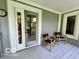 Covered porch has wood flooring, a door, and two chairs at 6438 Pin Oak Dr, McCordsville, IN 46055